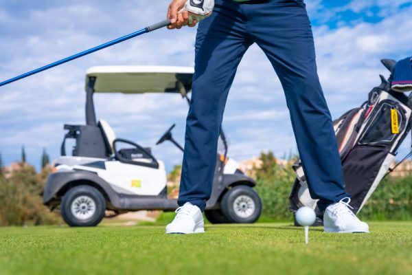 Golf driver stick preparing to hit the ball. Unrecognizable man playing golf